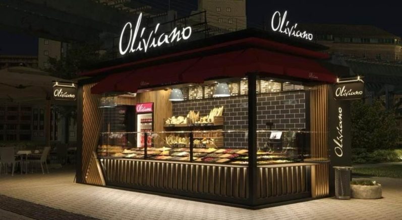 Oliva Uno Gastronomiecontainer – stilvoller Modulbau für Restaurants Modularer Restaurantcontainer Oliva Uno – Gastronomieeinheit mit Holzverkleidung, Überdachung und Kundenbereich im Außenraum