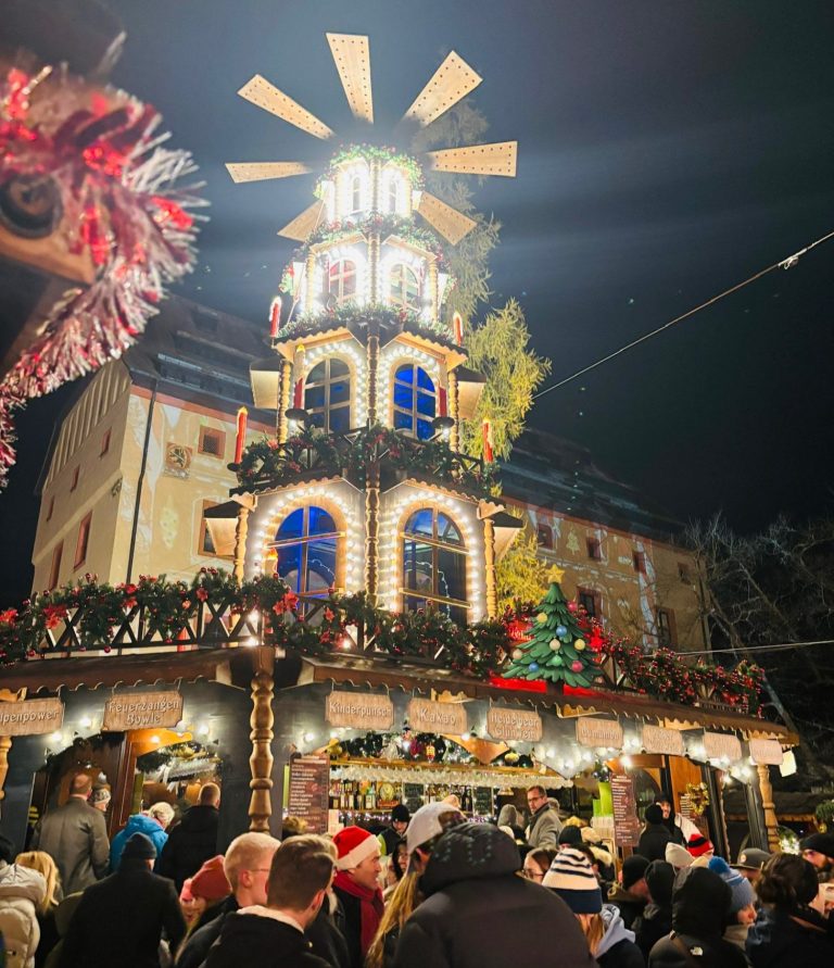3-stöckige Weihnachtspyramide mit Dekoration und Sternrad Große, beleuchtete Weihnachtspyramide mit Holzfassade und Krippe in der Altstadt